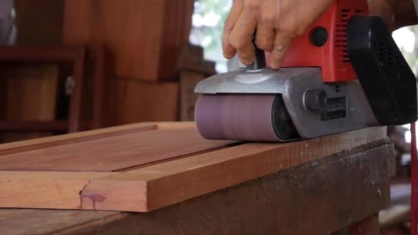Zanaatkar zıpzıp makinesini kullanırken marangozluk atölyesinde çalışır. İşçi taşlama ile mobilya parlatma. İnşaat aletlerinin yakınlaştırılması. Yavaş çekim — Stok video
