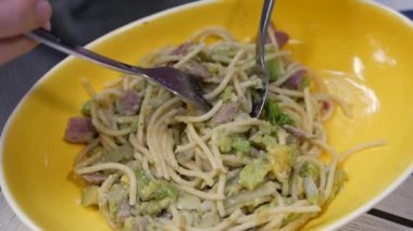 Parmesan, avokado ve pastırma ile İtalyan makarna carbonara yemek. Yavaş çekim. Closeup