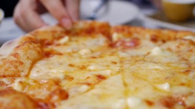 Kadın yemeye hazır erimiş peynir ile pizza bir parça almak. Oburluk ve zevk için lezzetli yemek. Fast food yeme konsepti. Yavaş çekim. Closeup