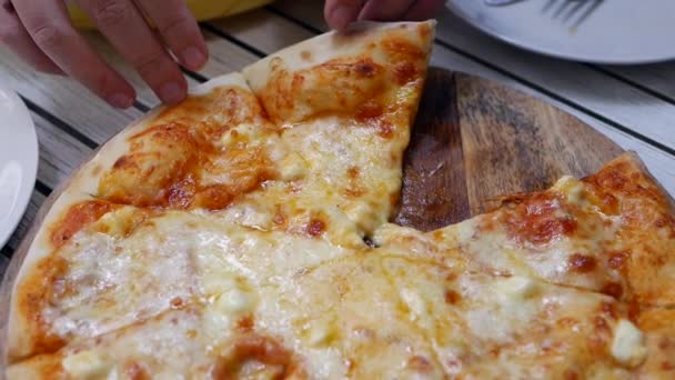 Frau nimmt ein Stück Pizza mit geschmolzenem Käse, fertig zum Essen. leckeres Essen für Völlerei und Genuss. Fastfood-Konzept. Zeitlupe. Nahaufnahme — Stockvideo