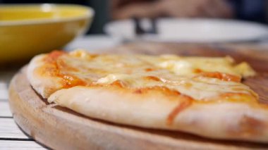 Yemeye hazır erimiş peynirli pizzanın yakın çekim çekimi. Oburluk ve zevk için lezzetli yemek. Fast food yeme konsepti. Yavaş çekim