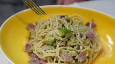 Parmesan, avokado ve pastırma ile İtalyan makarna carbonara yemek. Yavaş çekim. Closeup
