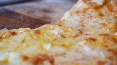 Kadın yemeye hazır erimiş peynir ile pizza bir parça almak. Oburluk ve zevk için lezzetli yemek. Fast food yeme konsepti. Yavaş çekim. Closeup