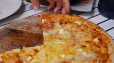 Kadın yemeye hazır erimiş peynir ile pizza bir parça almak. Oburluk ve zevk için lezzetli yemek. Fast food yeme konsepti. Yavaş çekim. Closeup