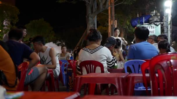 2019年8月15日、ベトナム、ニャチャン。夜のストリートフード市場で地元の人々とのシーン。外で夕食を食べてる食べる概念 — ストック動画