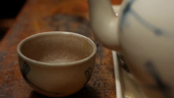 在咖啡馆的木桌上把红茶倒进一个小碗里 — 图库视频影像