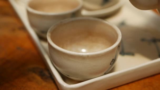 Pour red tea into a small bowl on a wooden table at cafe — Stock Video