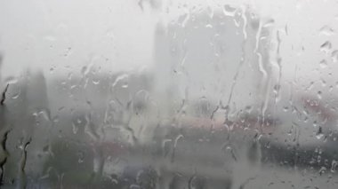 Güçlü yağmur suyu pencere camı karşı floşlar ve aşağı akar, yakın. Yağmur mevsiminde cam zemin üzerinde Raindrops. 4k