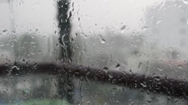Güçlü yağmur suyu pencere camı karşı floşlar ve aşağı akar, yakın. Yağmur mevsiminde cam zemin üzerinde Raindrops. 4k
