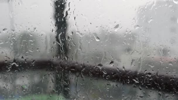 El agua de lluvia fuerte se enjuaga contra el vidrio de la ventana y fluye hacia abajo, de cerca. Gotas de lluvia sobre fondo de vidrio en temporada de lluvias. 4k — Vídeos de Stock