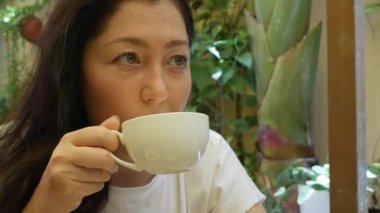 Güzel mutlu genç kadın sabah kafede kahve içiyor. kahve espresso veya çay zevk kadın model.