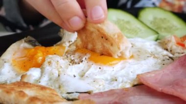 Kadın kızarmış yumurta, tost, jambon ve pastırma ile geleneksel İngiliz kahvaltısı yiyin. Close