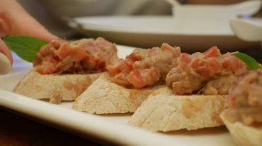 Kadın el bir restoranda bir tabak avokado ve domates ile bruschetta alır. Yakın çekim