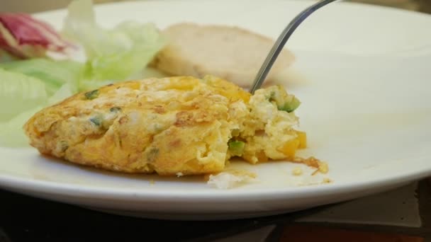 Someone eats omelet with fork in restaurant. Fried eggs with vegetables. Yummy. Close-Up — Stock Video