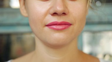 Genç bir kadın kokteyl içer, pipetle alkolden arınır ve gülümser. Yazlık kafede ferahlatıcı lezzetlerden hoşlanan bir kızın yakın plan portresi. Fitness ve sağlıklı yaşam tarzı konsepti. Kadın