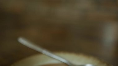 Barista masaya latte sanatıyla birlikte bir fincan kahve koyar. Eller kafeye bir fincan sütlü kahve koyar. Kahve molası. Yakın çekim.