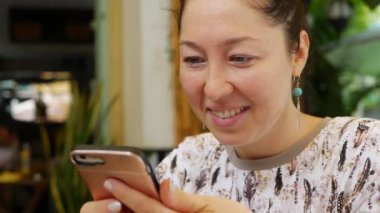 Mutlu kız akıllı telefon kullanıyor, mesaj yazıyor, sohbet ediyor. Telefonda bilgi arayan genç bir kadın. Arkadaşlarımla restoranda oturuyordum. Kahvaltı zamanı.