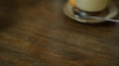 Barista masaya latte sanatıyla birlikte bir fincan kahve koyar. Eller kafeye bir fincan sütlü kahve koyar. Kahve molası. Yakın çekim.