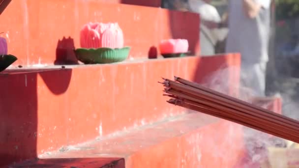 Les gens éclaircissent leurs bâtons d'encens lors de la célébration du Nouvel An chinois. Gros plan. 4k — Video