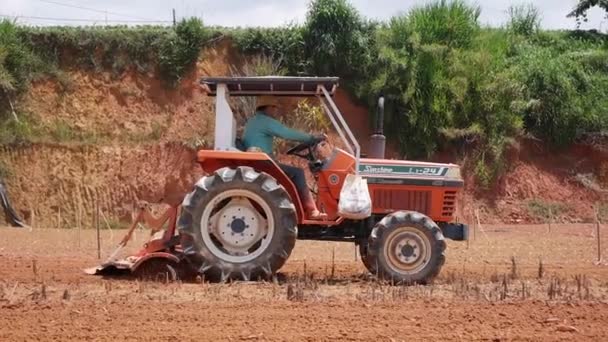 Traktori kyntää pölyinen kuiva maaperä ja valmistella kentän kylvöä. Luonnonmukainen viljely. Maatalous ja elintarviketeollisuus. DALAT, VIETNAM - kesäkuu 26, 2020 — kuvapankkivideo