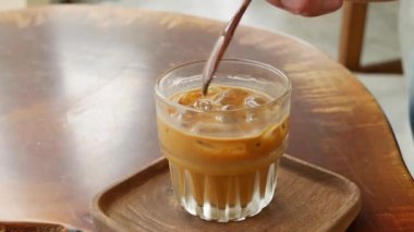 Müşteri karıştırıyor ve sütlü kahve içiyor. Kafede Vietnam Geleneksel phin filtresi. Ca phe sua da. Yakın plan.