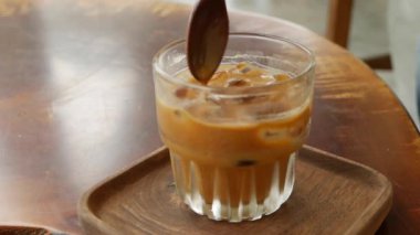 Müşteri içmeden önce sütlü kahve karıştırıyor. Kafede Vietnam Geleneksel phin filtresi. Ca phe sua da. Yakın plan.