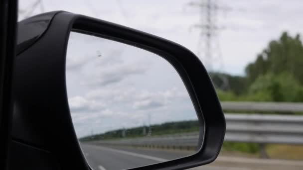 Pohled ze zpětného zrcátka jako auto řídí na venkovské silnici — Stock video