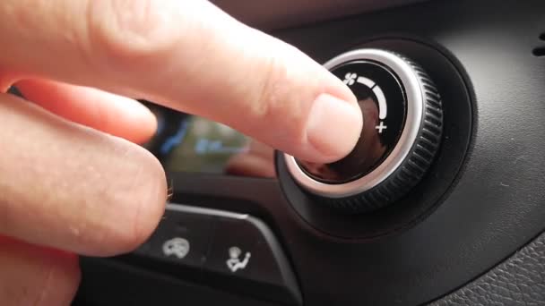 Крупным планом нажать кнопку, чтобы включить кондиционер в машине. Рука поворачивает кнопку и регулирует комфорт в машине — стоковое видео