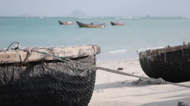 Barco redondo tradicional vietnamita en la playa de arena en el pueblo de pescadores en el fondo del mar. Buque pesquero y símbolo de cultura — Vídeos de Stock