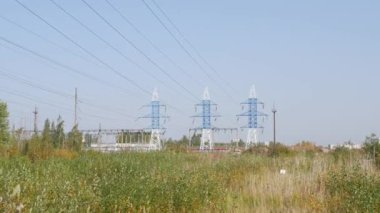 Gökyüzü arka planında elektrik hatları var. Kırsal kesimde elektrik kuleleri var. Ekoloji kavramı, çevre koruma.