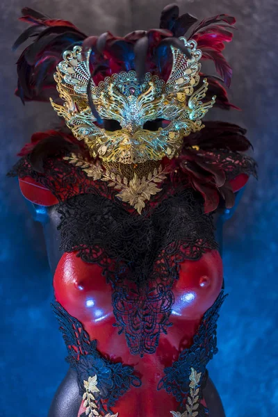 红色金色威尼斯狂欢节面具与羽毛在披着红色天鹅绒剧院窗帘 黑暗中的面具 — 图库照片