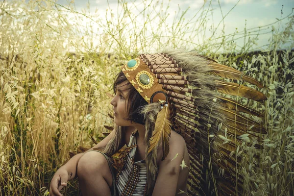 孩子在日落时身着美国印第安人的衣服 戴着印度羽毛羽和骨胸衣 在一个快乐面孔的谷物牧场旁边玩耍 — 图库照片