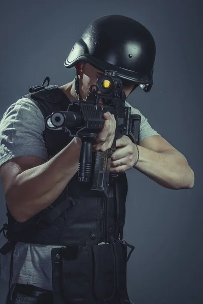 ピストル ブラックアーマー 機関銃を目的とした保護ヘルメットを身に着けている安全性 ペイントボールスポーツ選手 — ストック写真
