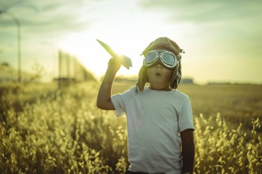 Eğlenceli, çocuk günbatımı havacı, olmakta oynarken o uçaklar ve bazı karton kanatları gibi pilot gözlük takar