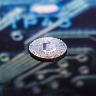 Bitcoin altın, gümüş ve bakır paralar ve çözülmüş baskılı devre arka planı. Sanal kripto para birimi kavramı.
