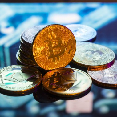 Bitcoin altın, gümüş ve bakır paralar ve çözülmüş baskılı devre arka planı. Sanal kripto para birimi kavramı.