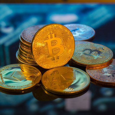 Bitcoin altın, gümüş ve bakır paralar ve çözülmüş baskılı devre arka planı. Sanal kripto para birimi kavramı.