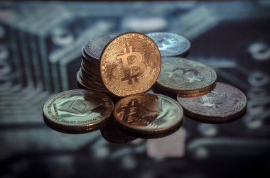 Bitcoin altın, gümüş ve bakır paralar ve çözülmüş baskılı devre arka planı. Sanal kripto para birimi kavramı.