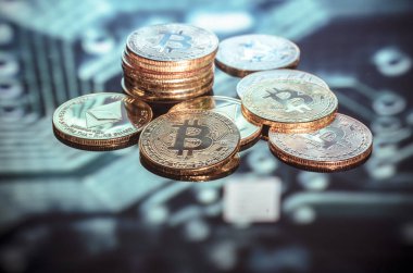 Bitcoin altın, gümüş ve bakır paralar ve çözülmüş baskılı devre arka planı. Sanal kripto para birimi kavramı.