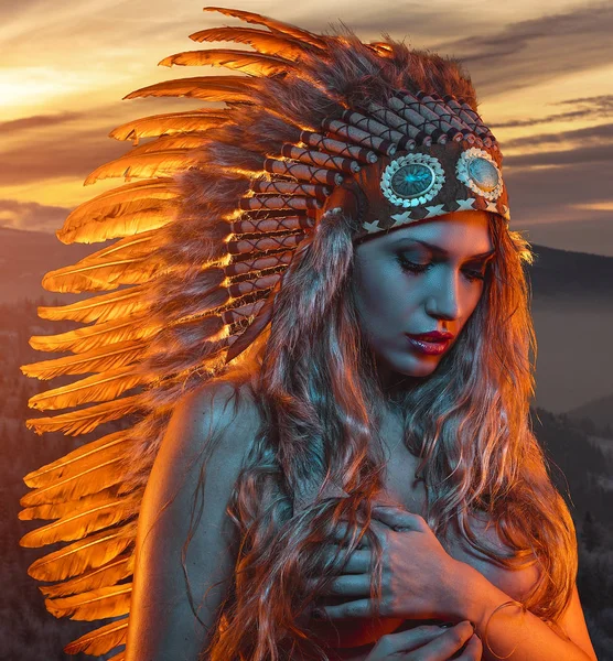 黄金の髪と茶色の羽の大きなアメリカインディアン プルームと官能的な顔を持つ美しいブロンド — ストック写真