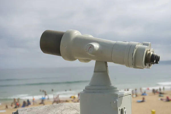 Coin operated binocular on the summer beach, tourist scene in Spain