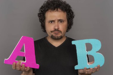 dönüşüm huni, A / B testi pazarlama ve online reklam. Esmer adam renkli harfler A ve B yüz ifadeleri ile elinde tutan