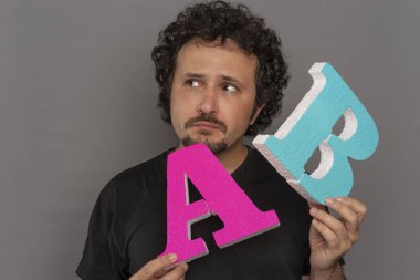 Web sitesi dönüşüm huni, A / B testi pazarlama ve online reklam. Esmer adam renkli harfler A ve B yüz ifadeleri ile elinde tutan