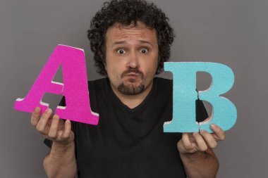 dönüşüm huni, A / B testi pazarlama ve online reklam. Esmer adam renkli harfler A ve B yüz ifadeleri ile elinde tutan