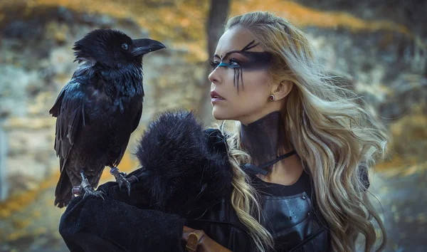 Güzel siyah karga, kalkan ve kılıç, Viking sarışın kadınla saçlarına örgü.