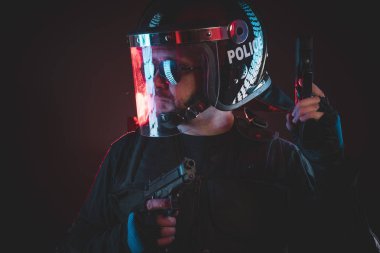Kırmızı hasar ışıkları ile çatışma çevik kuvvet polisi. silahlı adam kask ve kurşun geçirmez yelek
