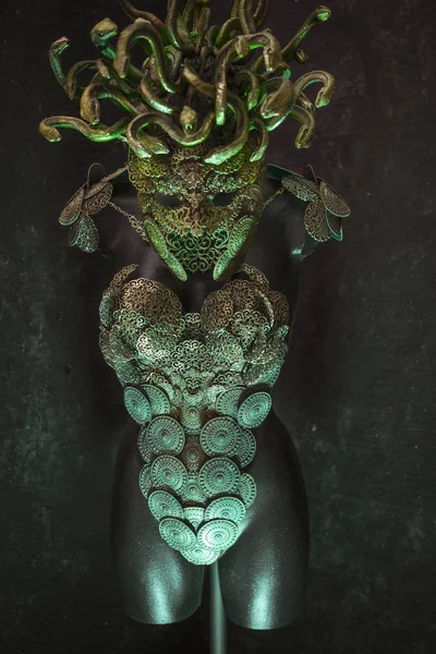 Medusa, creature of Greek mythology. pieces made by hand with goldsmiths and metals such as gold and copper. wears a helmet of green and gold snakes