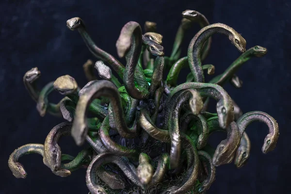 Head Medusa, creature of Greek mythology. pieces made by hand with goldsmiths and metals such as gold and copper. wears a helmet of green and gold snakes