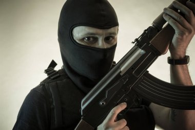 Hırsız, av tüfeği ve kurşun geçirmez yelek ile silahlı adam