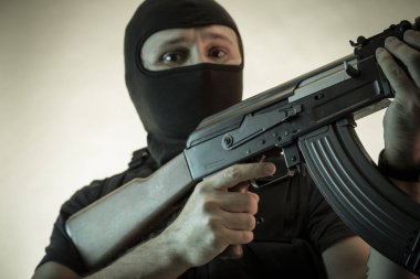 Hırsız, av tüfeği ve kurşun geçirmez yelek ile silahlı adam